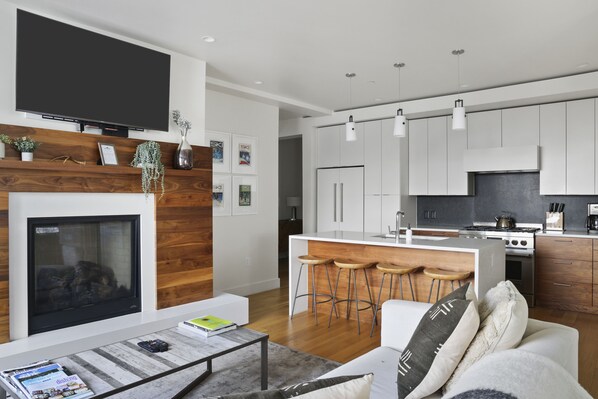 A modern living room with a fireplace, a TV, and a coffee table.