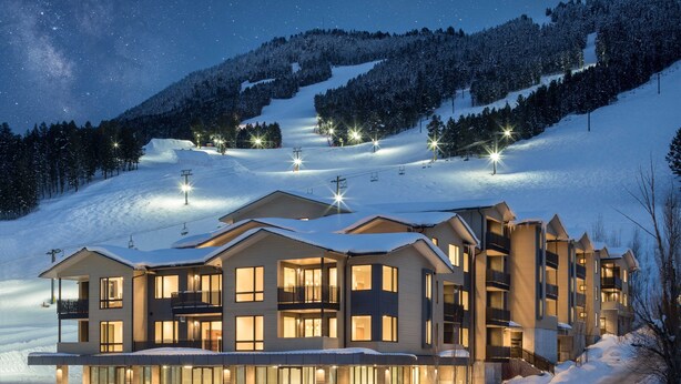 A multi-story hotel with a ski lift in the background, surrounded by snow-covered hills. - Outpost: One Town Hill 507 - Base of Snow King Mtn (Jackson)