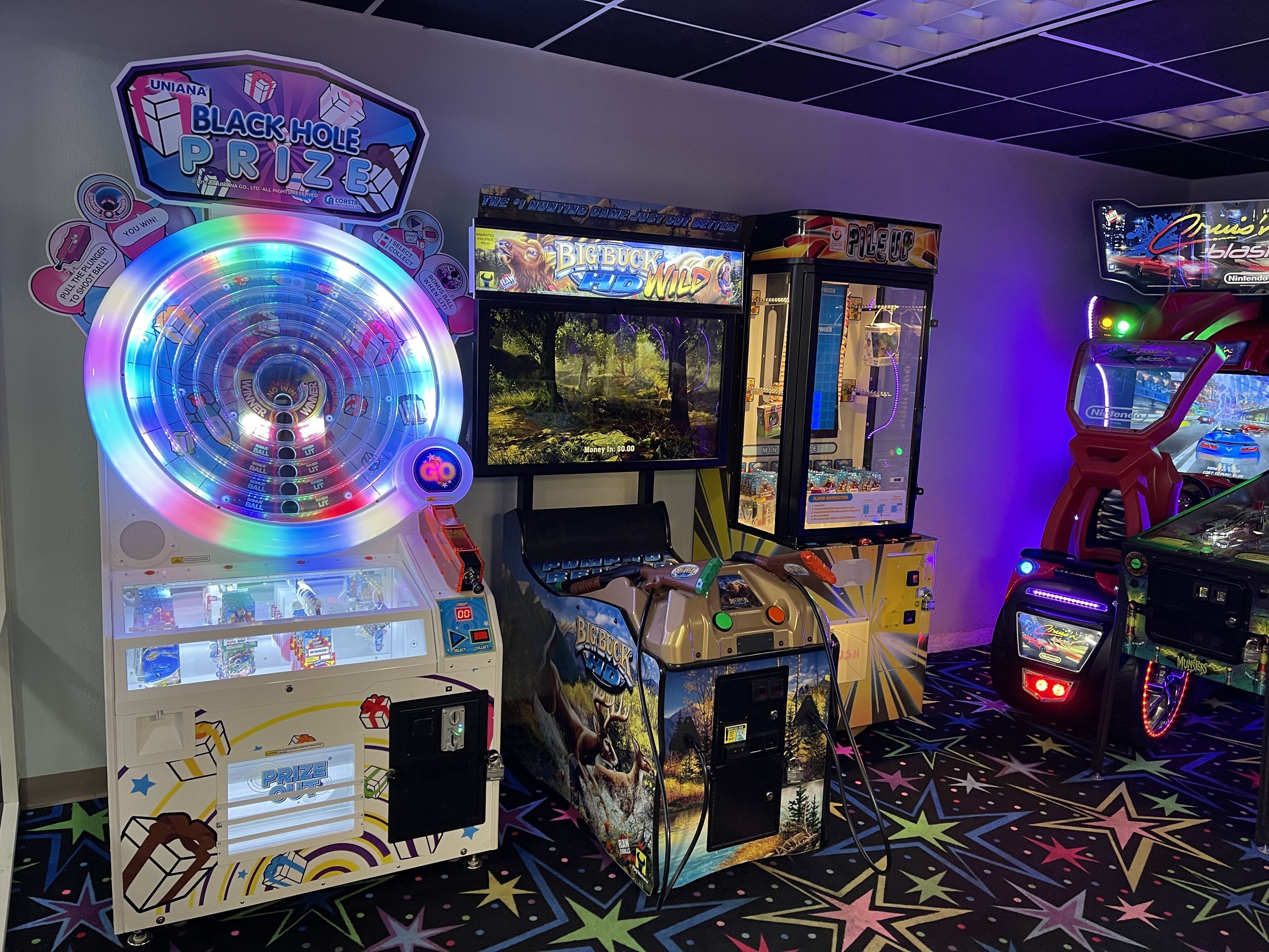 Une salle d’arcade proposant divers jeux, notamment une roue de la fortune et un jeu de course.