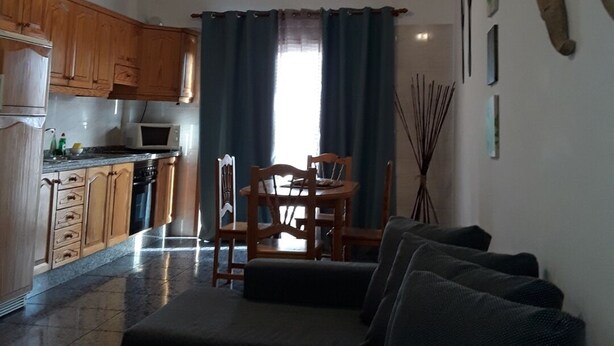 Un espacio habitable compacto con kitchenette, comedor y zona de estar.