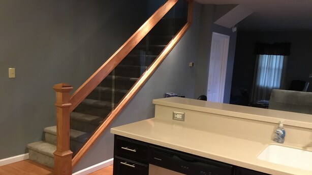 Une cuisine équipée d’un lave-vaisselle, d’un évier et d’un escalier en bois.