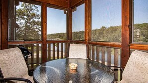 A wooden-paneled room with a round glass table and two patterned chairs. - Lake Front next to the Pool! In Stonebridge by Silver Dollar City (Branson West)