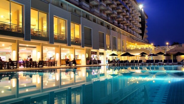 A hotel with a swimming pool, multiple balconies, and outdoor seating areas. - Hotel Ephesia (Kuşadası)