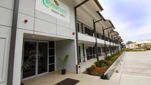A modern Rossroads Transit Hotel with a clean facade, large windows, and a covered outdoor area with seating. - Crossroads Hotel Lae (Lae)