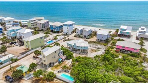 A coastal residential area with houses, a swimming pool, and a beach. - Pineapple Plantation - Gulf view, Family friendly, Private pool, Lots of games & amenities, Pet friendly, Sleeps 10 (Cape San Blas)