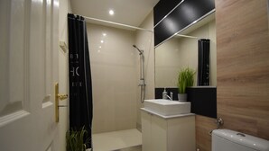 Un baño moderno con ducha, lavabo e inodoro.