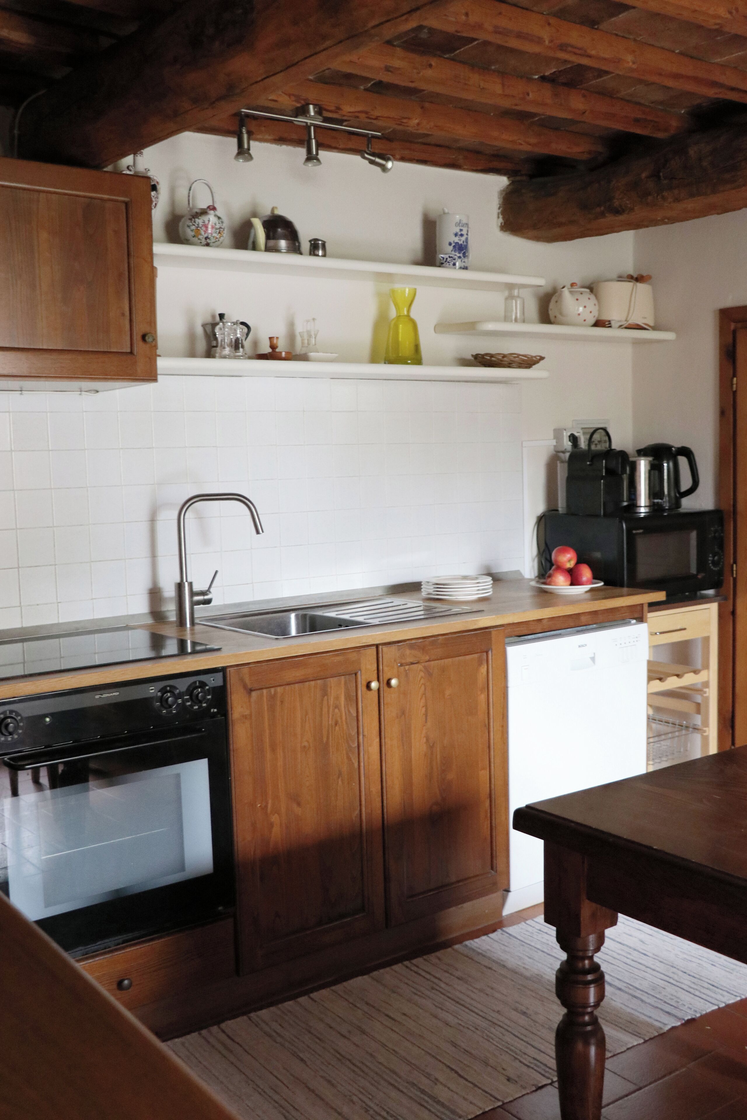 A kitchen with wooden cabinets, a dishwasher, a sink, and a microwave.