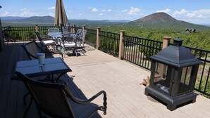 Terraza con mobiliario exterior, un farol y vistas a una montaña y un valle.