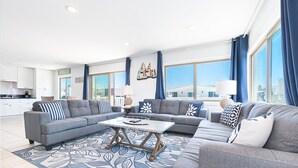 A modern living room with a grey sectional sofa, a coffee table, and a patterned rug.