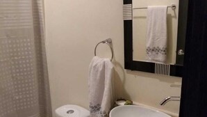 Une salle de bain avec des toilettes, un lavabo et un miroir.