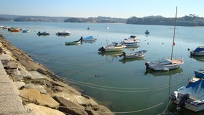 A marina with several boats docked, a rocky shoreline, and a clear sky. - Stunning Barn Conversion located in the heart of the Galician countryside (A Coruna)