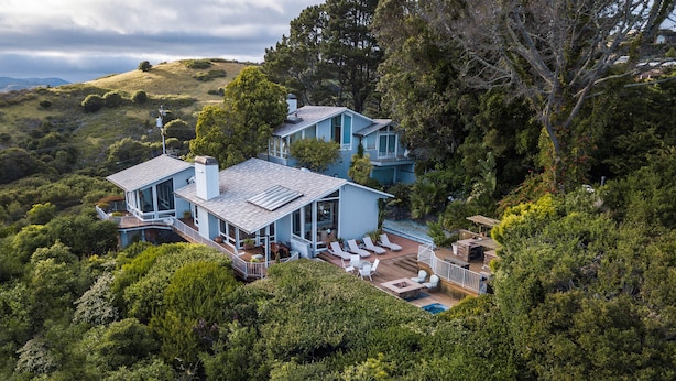 A large, light blue house with multiple levels, surrounded by dense greenery and hills. - Luxury, San Francisco Bay Area (Tiburon): 5000 sq. ft., 4 bed, 5 bath (Tiburon)