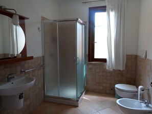 Een douche, een haardroger, een bidet, handdoeken