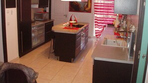 A kitchen with dark cabinets, a microwave, a stove, and a sink.