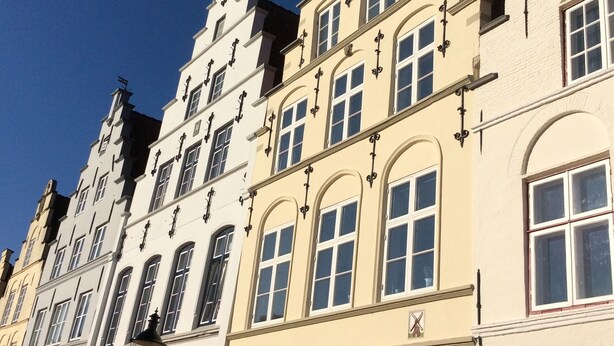 A row of traditional European buildings with a pub sign indicating a local establishment. - Original holiday in the westcoast STORE in Friedrichstadt / North Sea for 2-4 P.  (Friedrichstadt)