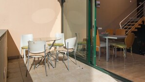 Un espace repas séparé par une cloison en verre, un escalier et une vue sur l’intérieur.