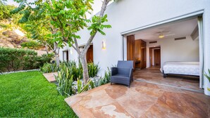 Ein modernes Haus mit Terrasse, einem Bett und einem Sessel.