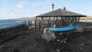 A beachside gazebo with a thatched roof, overlooking the ocean. - An oasis in the desert of civilization (FUERTEVENTURA)