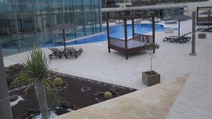 A pool area with lounge chairs and a wooden deck. - An oasis in the desert of civilization (FUERTEVENTURA)
