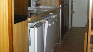 Una cocina compacta con microondas, lavabo y lavavajillas.