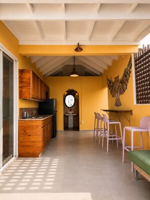 A kitchen with wooden cabinets, a sink, and a dining area with chairs and a table.