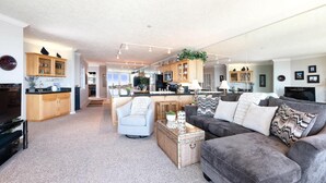 Ein großzügiger Wohnbereich mit einer Couch, einem Couchtisch und einer Küche im Hintergrund.