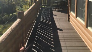 A wooden deck with a railing, a table, and chairs, overlooking a forested area. - All Star Acres 2 Miles To Park
5 BR,3 baths
 Dates align with Dreams Park ONLY! (Milford)
