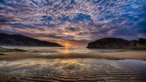 A beach with calm waters reflecting the sky, a sunset, and rocky cliffs. - Beautiful Holiday Cottage, Dunfanaghy, Donegal (Dunfanaghy)