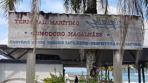 A signboard with the text 'TERMINAL MARÍTIMO COMODORO MAGALHÃES' and 'CONVÊNIO DE USO TAMOIOS LATE CLUB-PREFEITURA DE BATUBA'. - 4 bedroom apartment in ubatuba close to the beach (Ubatuba)