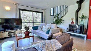 A modern living room with a large TV, a sofa, a coffee table, and a fireplace. - House / Villa - Aubenas (Aubenas)