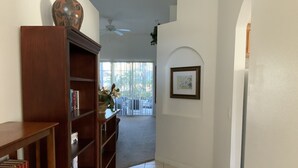 A hallway with a wooden bookshelf, a framed picture on the wall, and a tiled floor. - Spacious, LUXURY 4 bedroom villa with pool and spa close to Disney (Haines City)