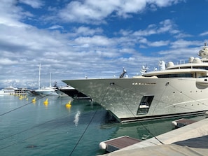 Een jachthaven met meerdere jachten aanmeren, met een heldere lucht en rustig water.