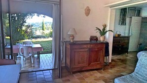 A room with a dining area, a wooden cabinet, and a view of the outdoors. - Holiday Gite in Southern Ardeche (Joyeuse)