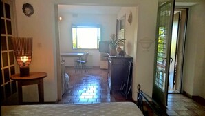 A hotel room with a bed, a desk, a chair, a potted plant, and a window. - Holiday Gite in Southern Ardeche (Joyeuse)