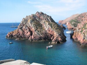 A rocky coastal landscape with boats anchored near the shore. - CASA SÃO JOÃO T1 - 1 bedroom apartment 100 m from the beach (Peniche)