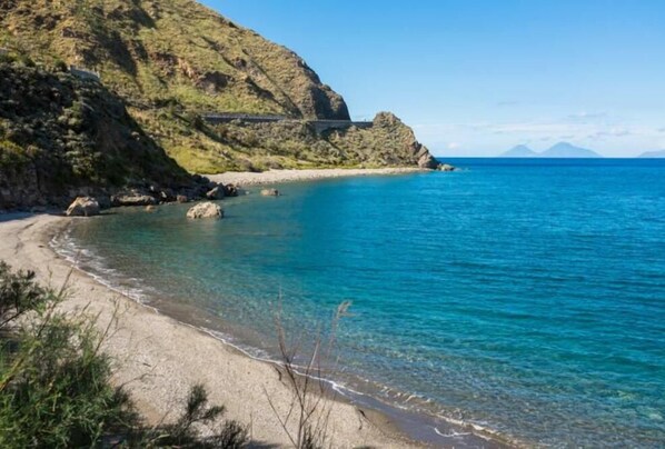 Overlooking the serene coastline, this property offers breathtaking views of the ocean and surrounding mountains.