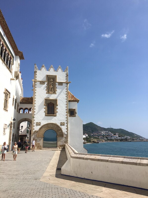 A historic white building with a prominent arched entrance and a tower with battlements. - Perfect holiday Sitges, private villa, pool, beach, lots of character! (Barcelona)