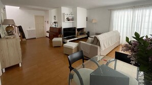 Ett rymligt vardagsrum med ett piano, en tv och en soffa.