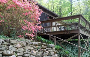 A rustic wooden bridge with the number 209, leading to a building with a balcony.