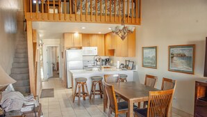 Una cocina amplia con armarios de madera, una isla central y taburetes de bar.