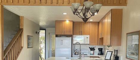 A spacious kitchen with wooden cabinets, a central island, and a dining area with a large table and chairs.