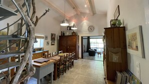 A spacious kitchen with a dining area, wooden cabinets, and a staircase.
