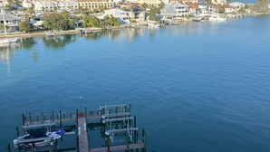 Un port de plaisance avec des bateaux amarrés et une vue dégagée sur le paysage urbain côtier en arrière-plan.