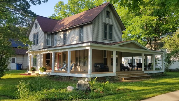 A two-story house with a covered porch and a front yard. - Relax in your home; yards from the Frankfort Beach and the downtown attractions. (Frankfort)