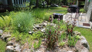 A garden with a variety of plants and a small pond. - Relax in your home; yards from the Frankfort Beach and the downtown attractions. (Frankfort)