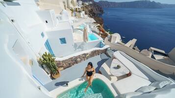 Un resort con piscina, architettura bianca e vista sul mare.