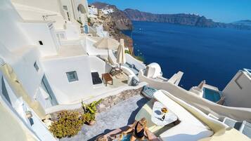 Un bâtiment aux murs blancs, doté d’une piscine, d’un espace extérieur aménagé et offrant une vue sur la mer.