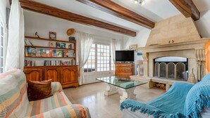Ein Wohnzimmer mit Kamin, Bücherregalen, einem Fernseher und einem Sofa.