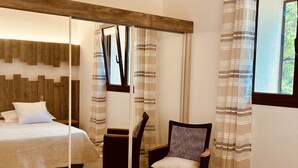 A bedroom with a bed, a chair, a window, and a wooden ceiling. - VILLA en Pierre 4 persons near PORTO-VECCHIO HEATED SWIMMING POOL  (Lecci)