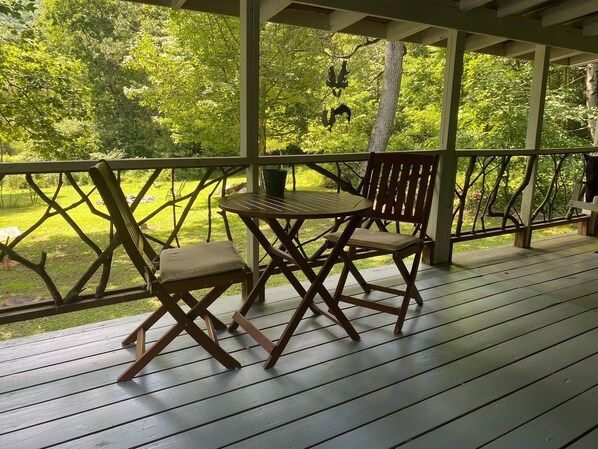 Relax on the covered deck with comfortable seating and a small table.